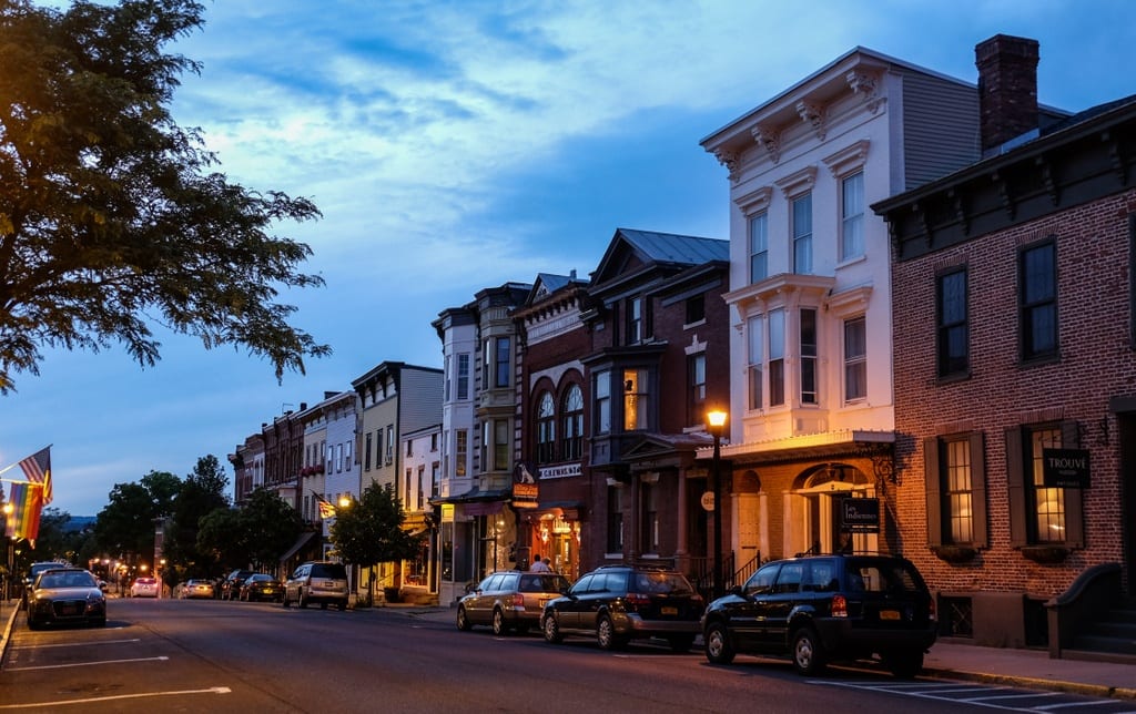 Warren Street at twilight, the sky dark blue and the street lamps turning on.