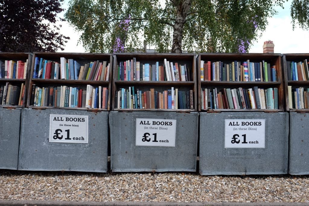 Rows of used books for sale with a sign labeled "all books 1 pound" in Haye on Wye, Wales.