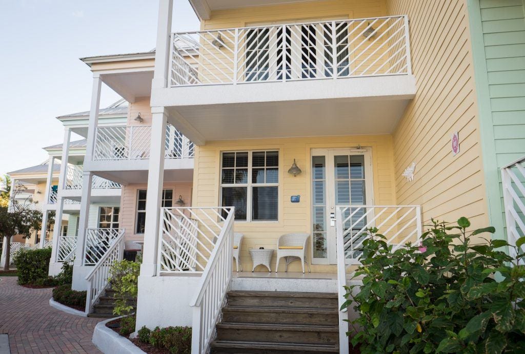 A butter-yellow cottage with white trim and a porch in Islamorada, Florida Keys.