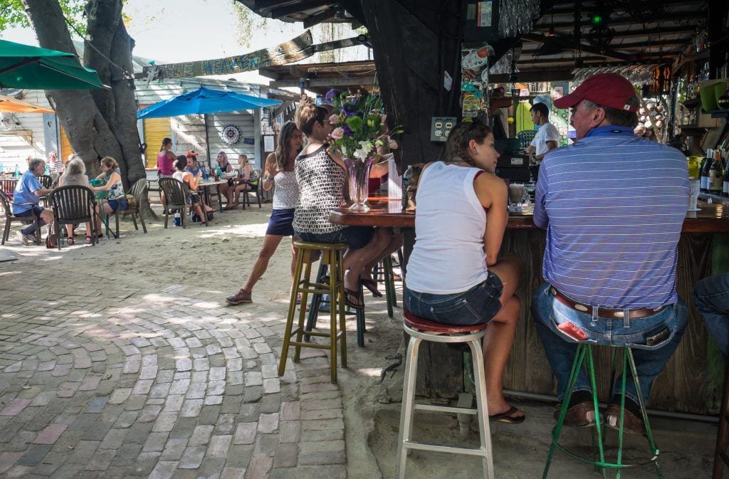 People sitting at the bar outside at Blue Heaven, a restaurant in Key West.