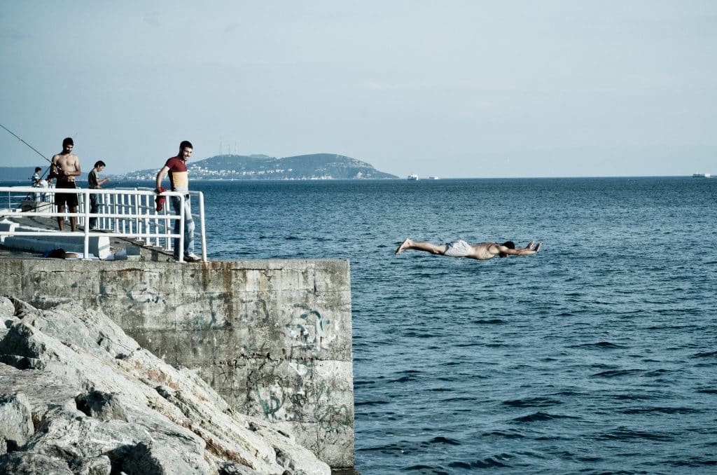 A man doing a belly flop into the water in Istanbul