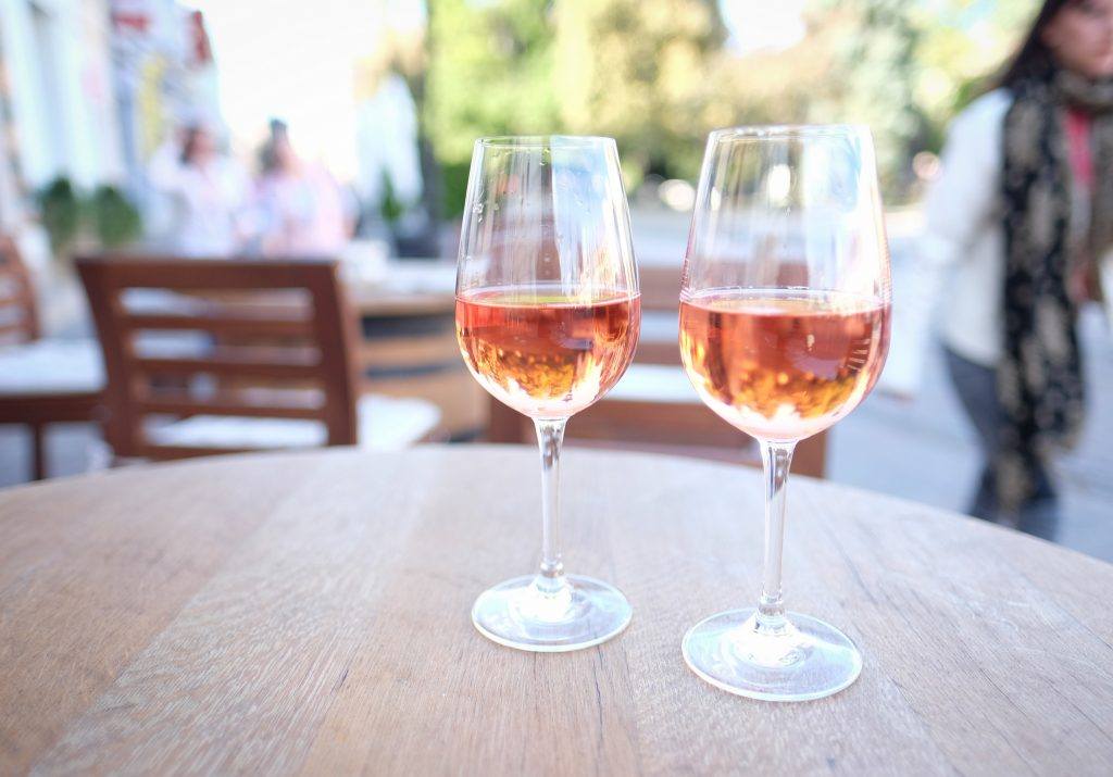 Two glasses of sparkling rose on a table.