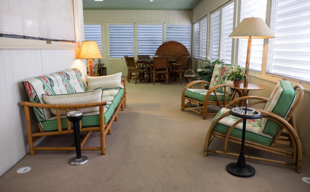 Truman's Little White House in Key West -- a sitting room with wooden chairs with green cushions, and a poker table in the corner.