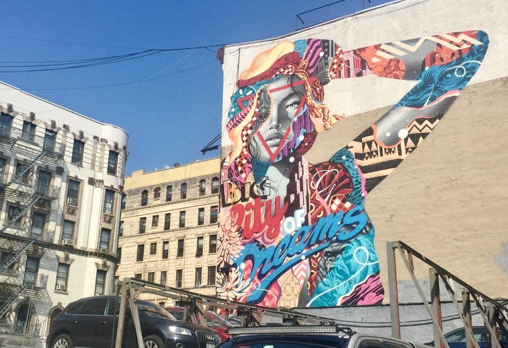 Street art in SoHo, NYC: an image of a rainbow-colored woman holding her hand to her head in pleasure.