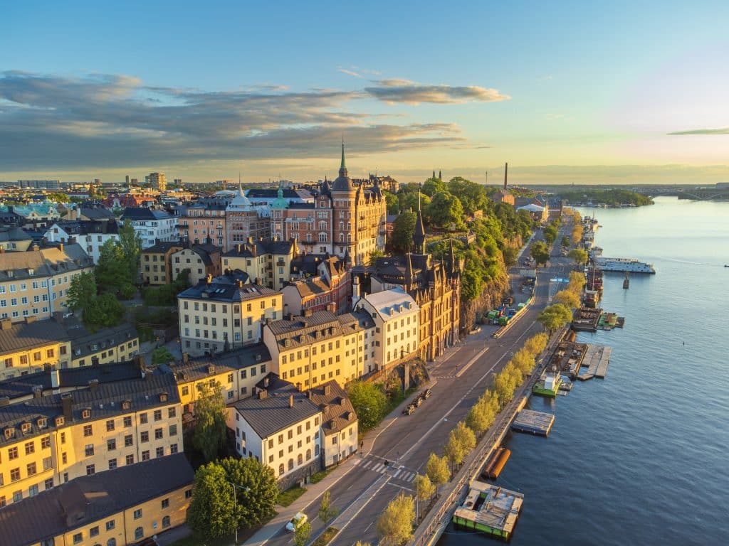 The yellow buildings of Stockholm's old town, perched on the edge of the sea and bathed in golden light at sunset.