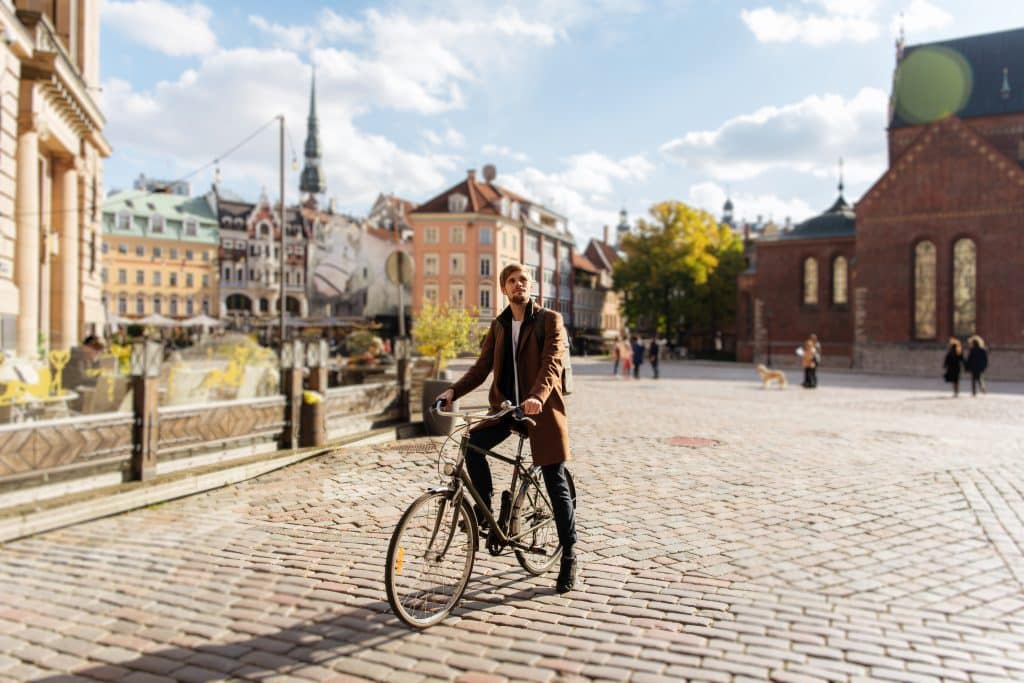 A man on his bicycle on a cobblestone street in Stockholm.