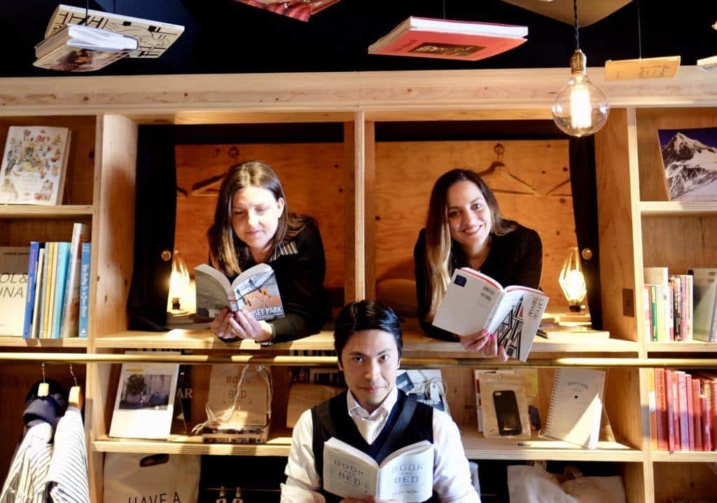 Kate and her friends Jess and Hai reading books at a hoot hostel in Tokyo.