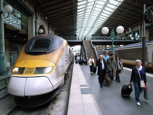 Taking a trip from London to Paris by train, a yellow train prepares to leave the station.