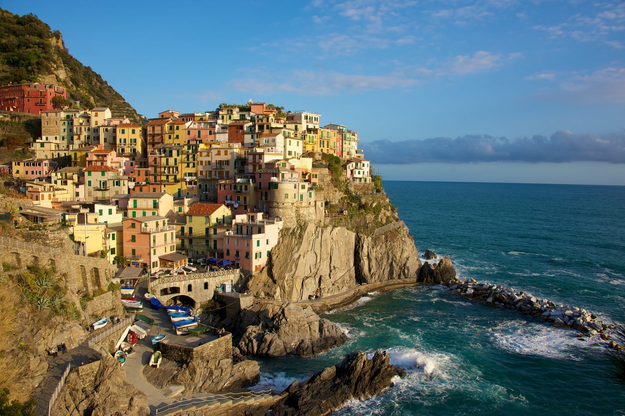 Aerial view of a town in Cinque Terre, showing the houses up the mountainside and the water down below
