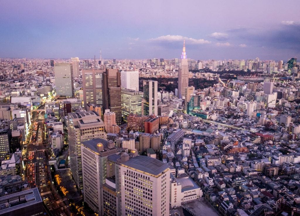 famous short stories about travel Tokyo at Sunset from the Park Hyatt, lit up in lavender.