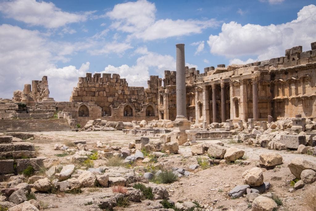 The sand-colored Roman ruins of Baalbek -- looks like a bombed out landscape, all orangey brown underneath a partly cloudy sky.