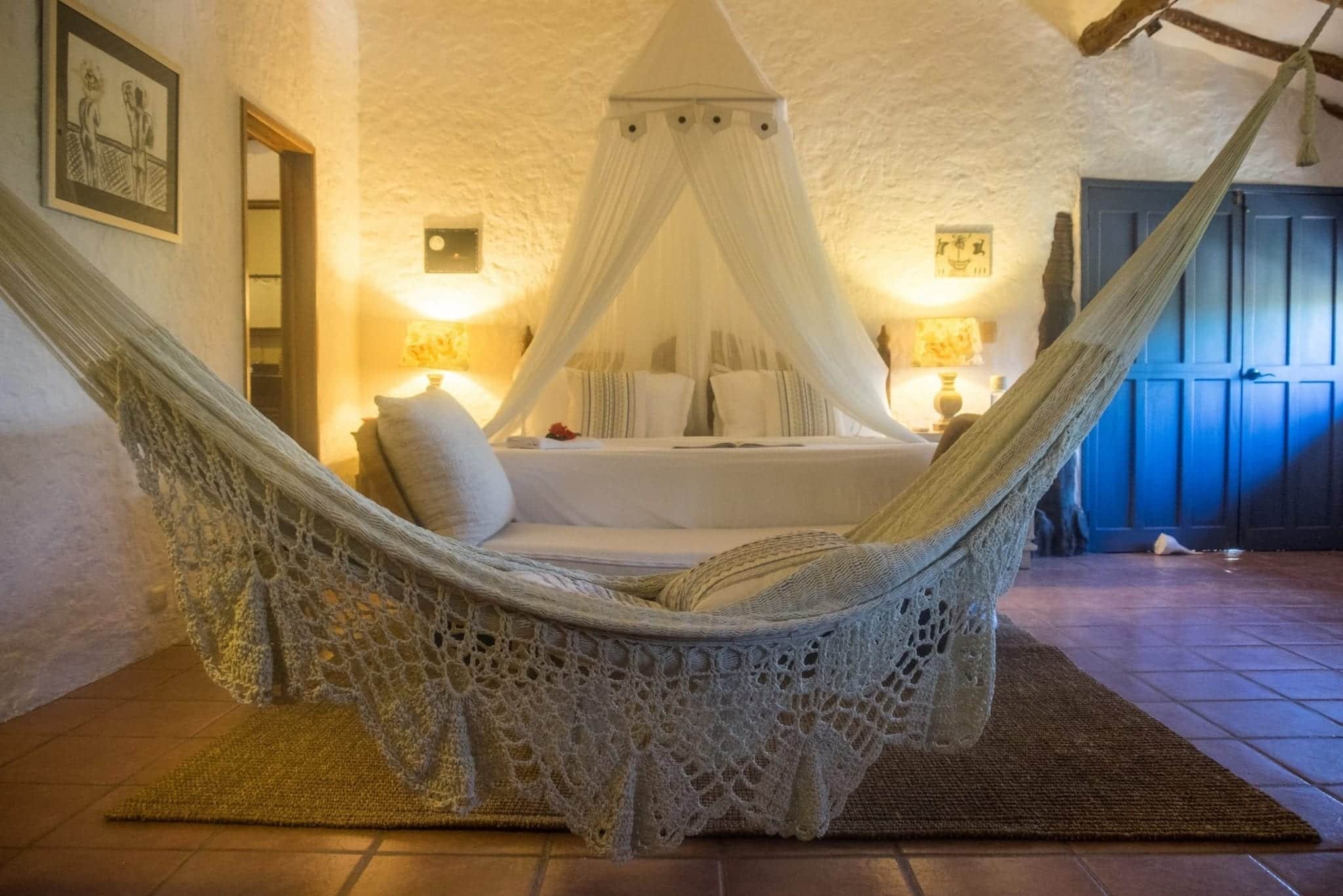 View of bedroom with hammock and bed.