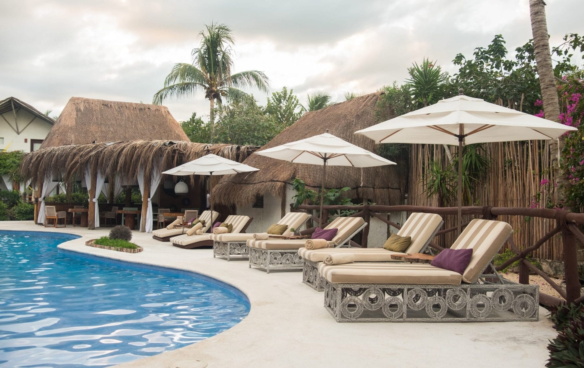 Lounge chairs with umbrellas beside the pool.