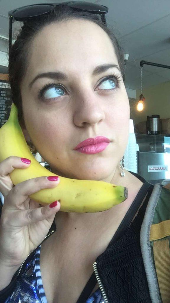 Kate looking sideways and holding a banana like it's a phone.