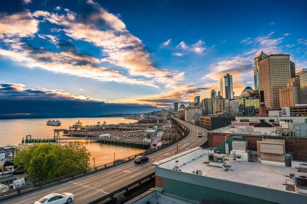 Bright blue sky and lit-up clouds at dusk on the Seattle skyline.