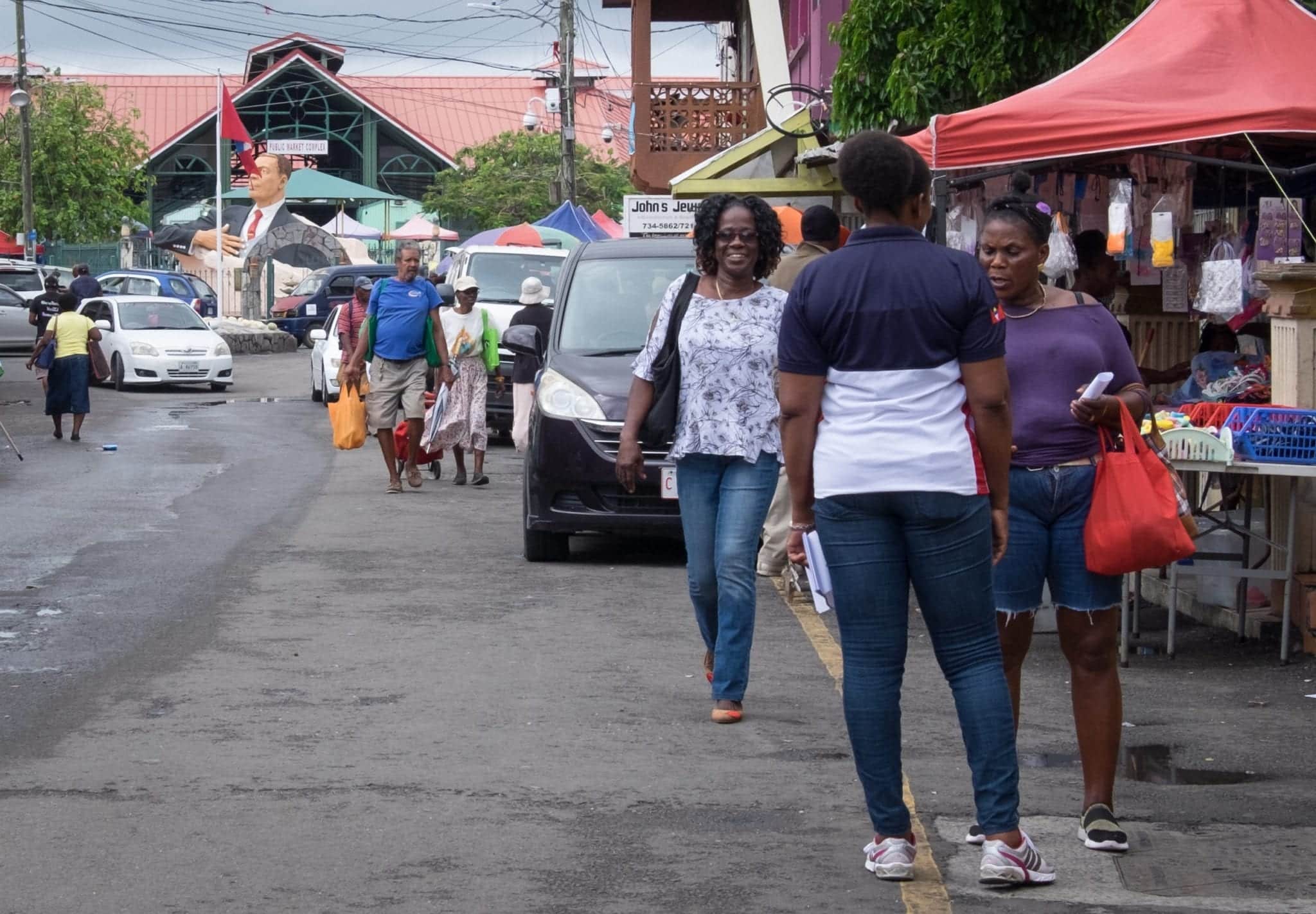 Two women green each other when walking down the street in St. John's Antigua.