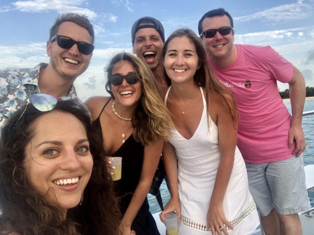 Kate and a group of several friends posing and smiling on a catamaran in Antigua