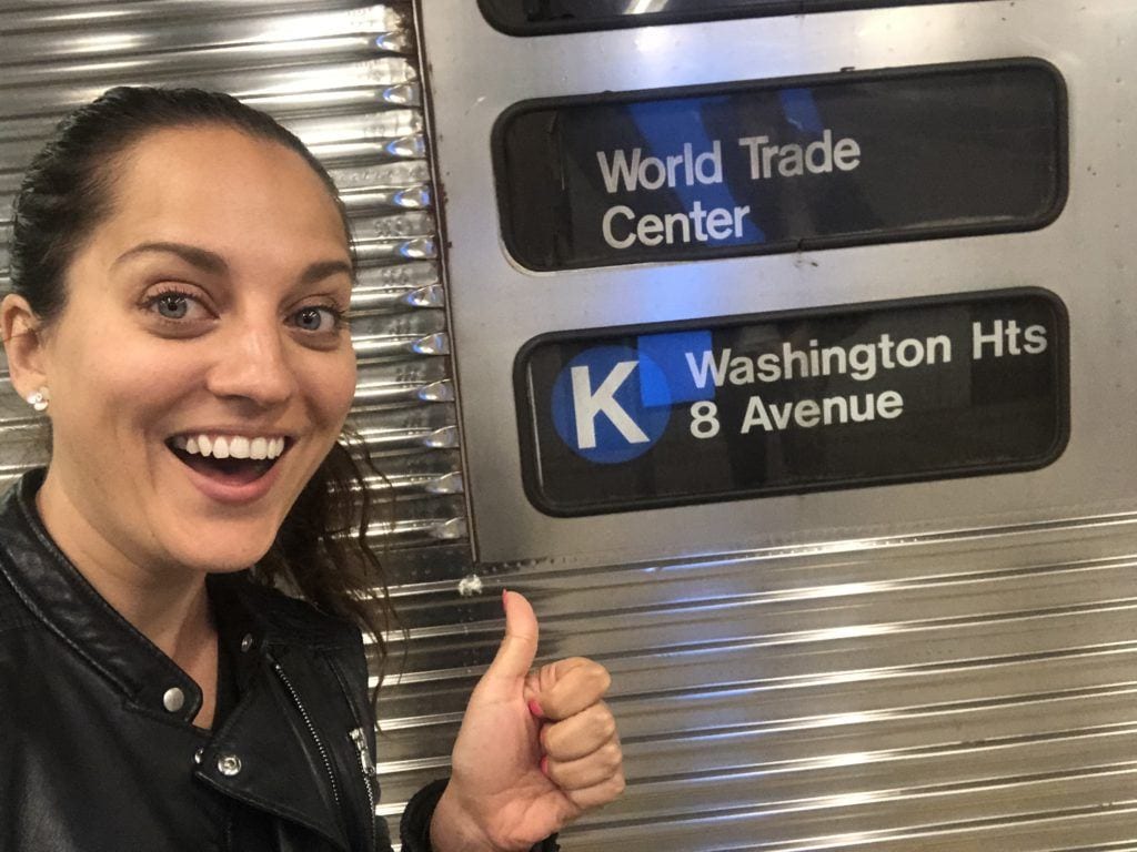 Kate stands in front of a New York subway train reading "K train" (a line that doesn't exist)