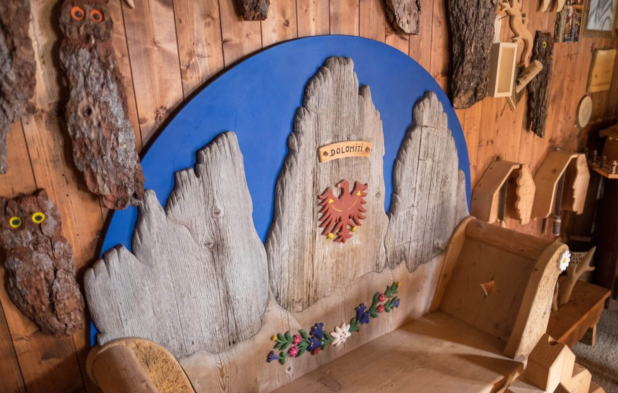 A bench carved in the shape of the Dolomites with a blue sky behind the jagged mountains.