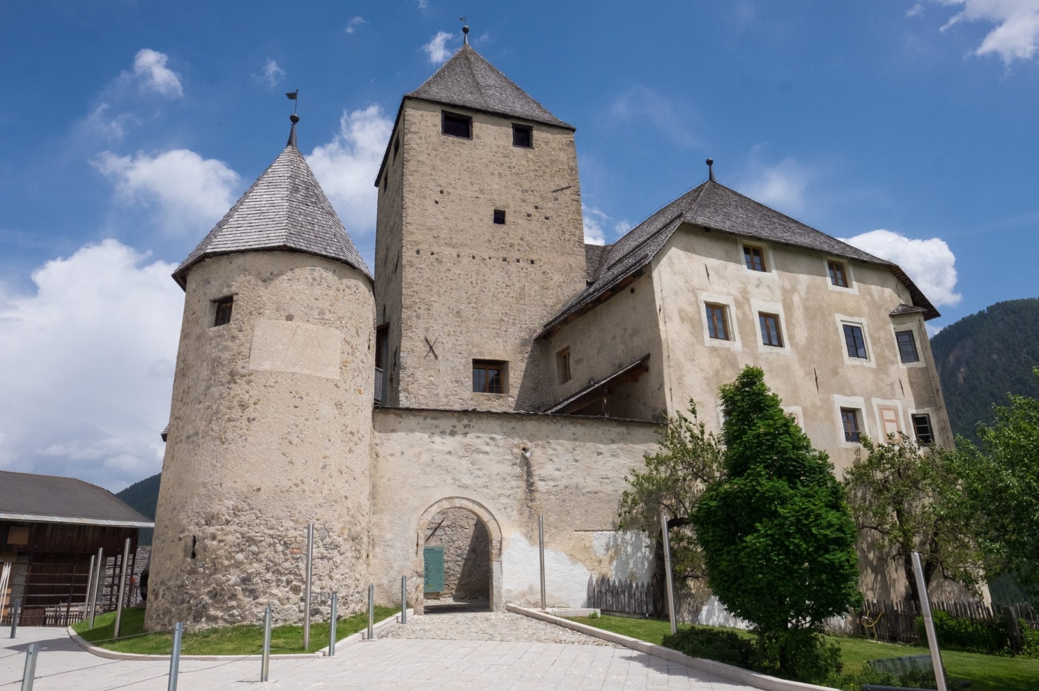 The Ladin Museum looks like a mini castle -- a stone building with a turret peeking out, set against a blue sky with clouds.