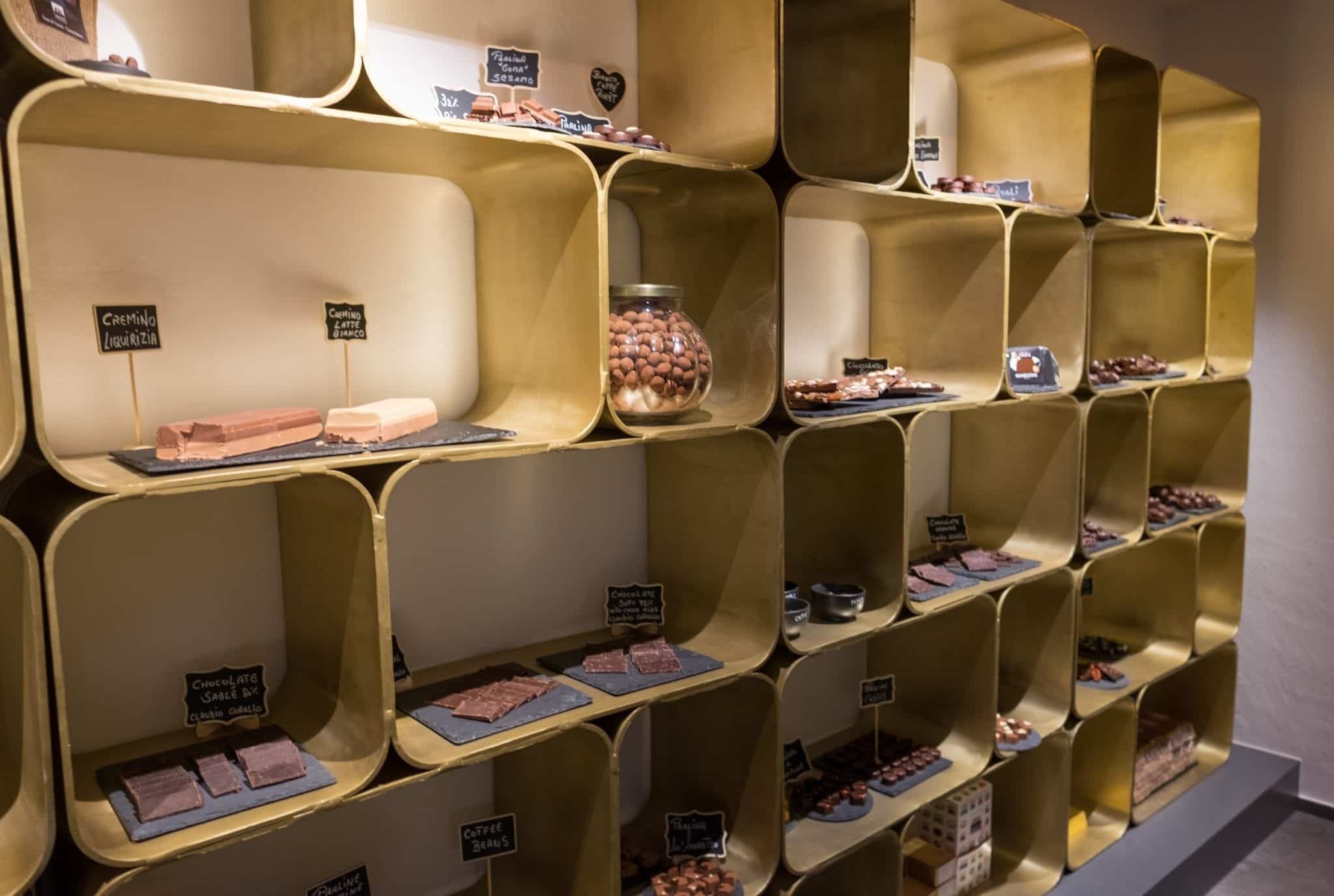 A wall filled with cube-shaped shelves, each filled with different kinds of chocolate.