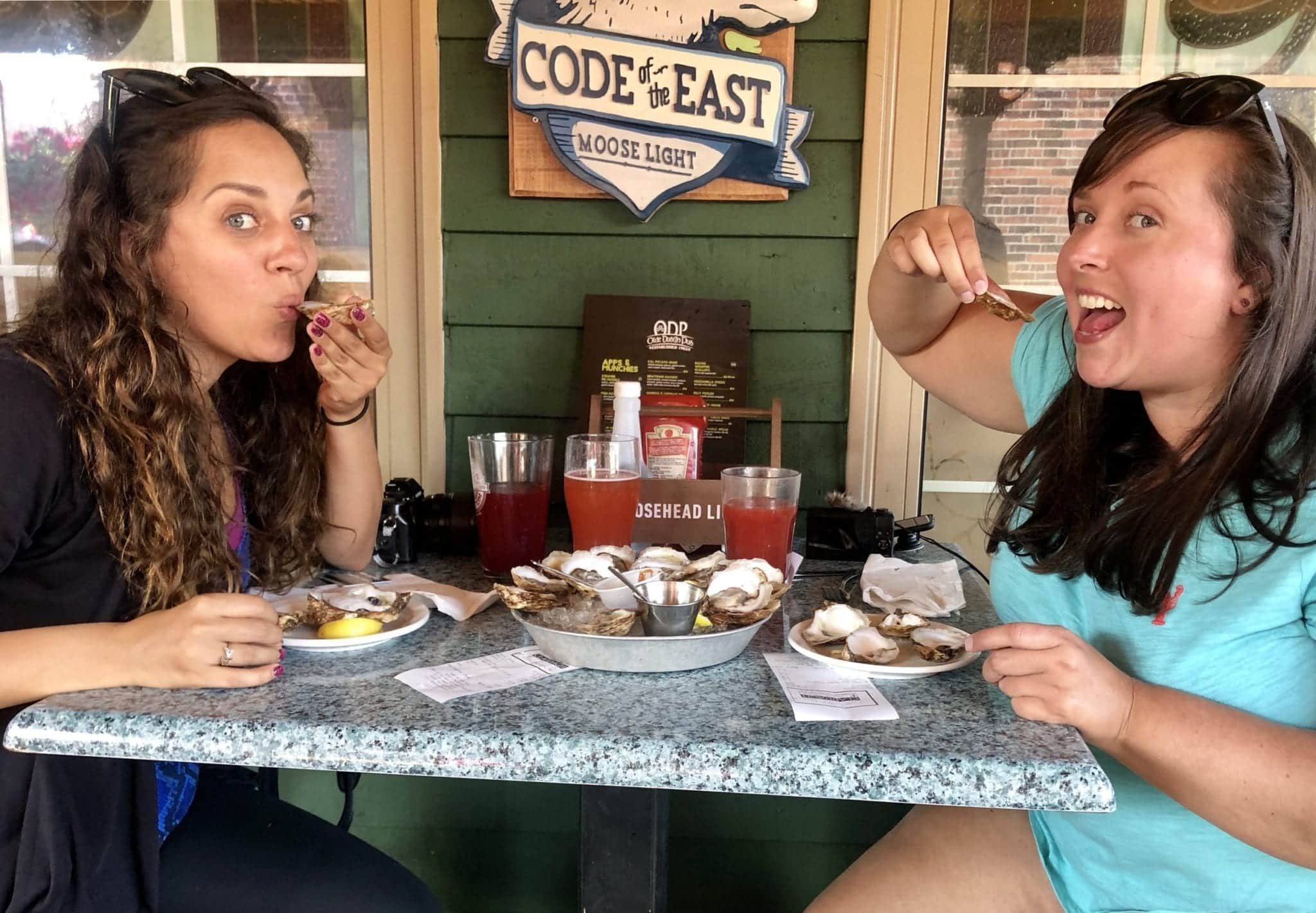 Kate and Cailin pause while eating a plate of 24 oysters at an Irish bar in PEI