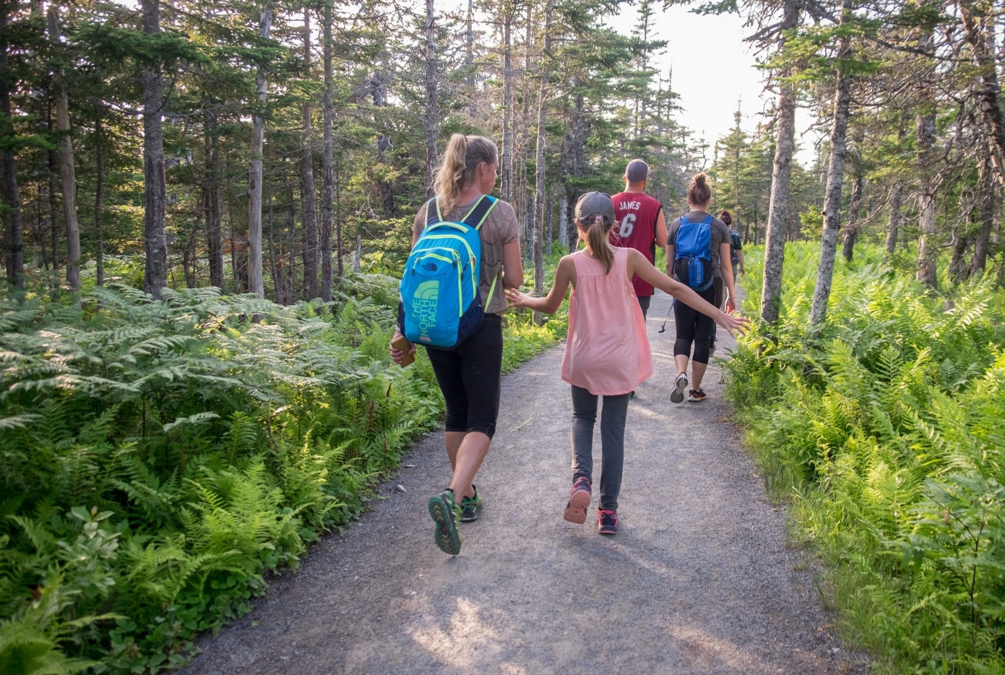 A mother and daughter walking along a forested path in Cape Breton Highlands National Park.