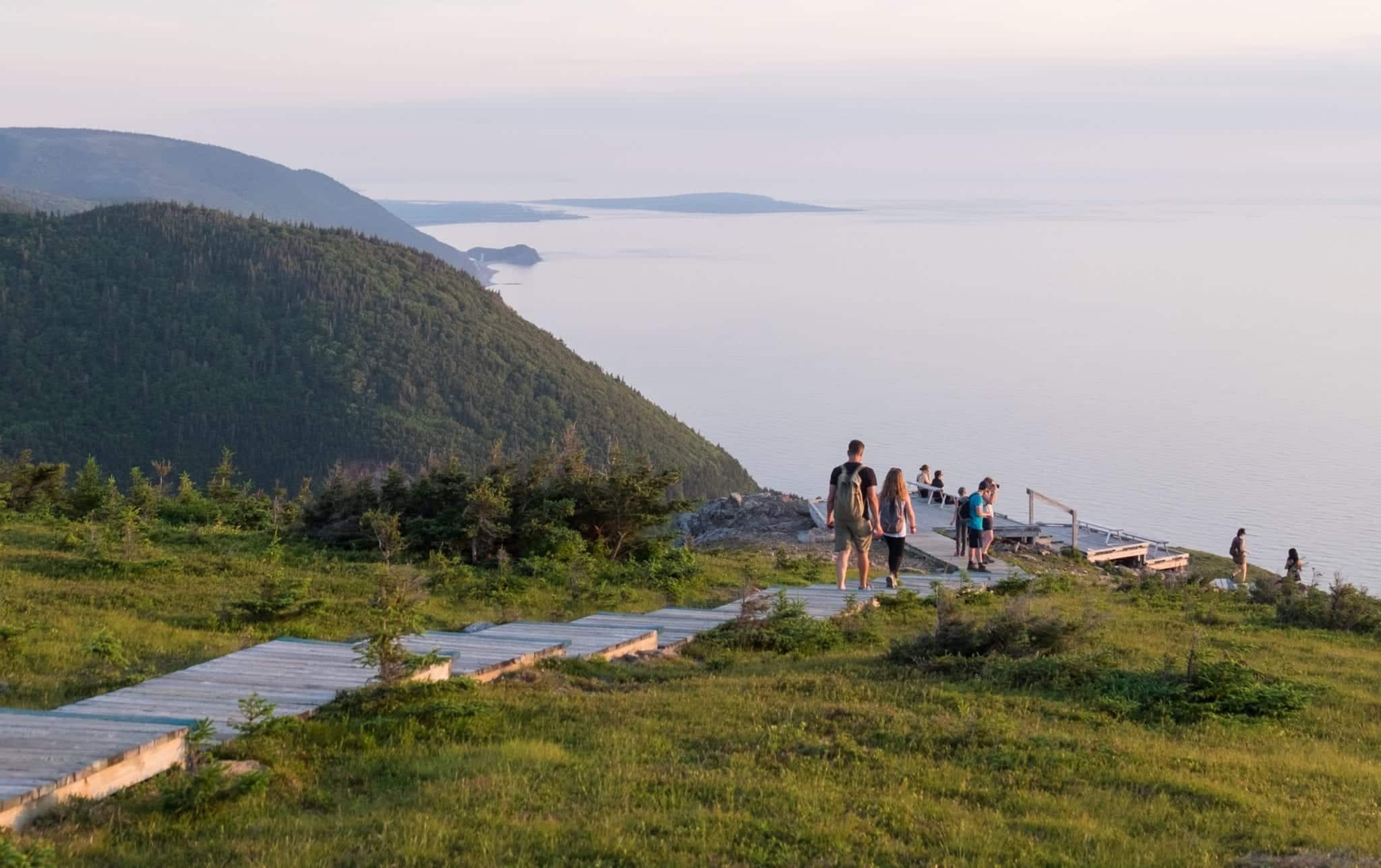 People walking down a staircase built into the hills at Cape Breton Highlands National Park.