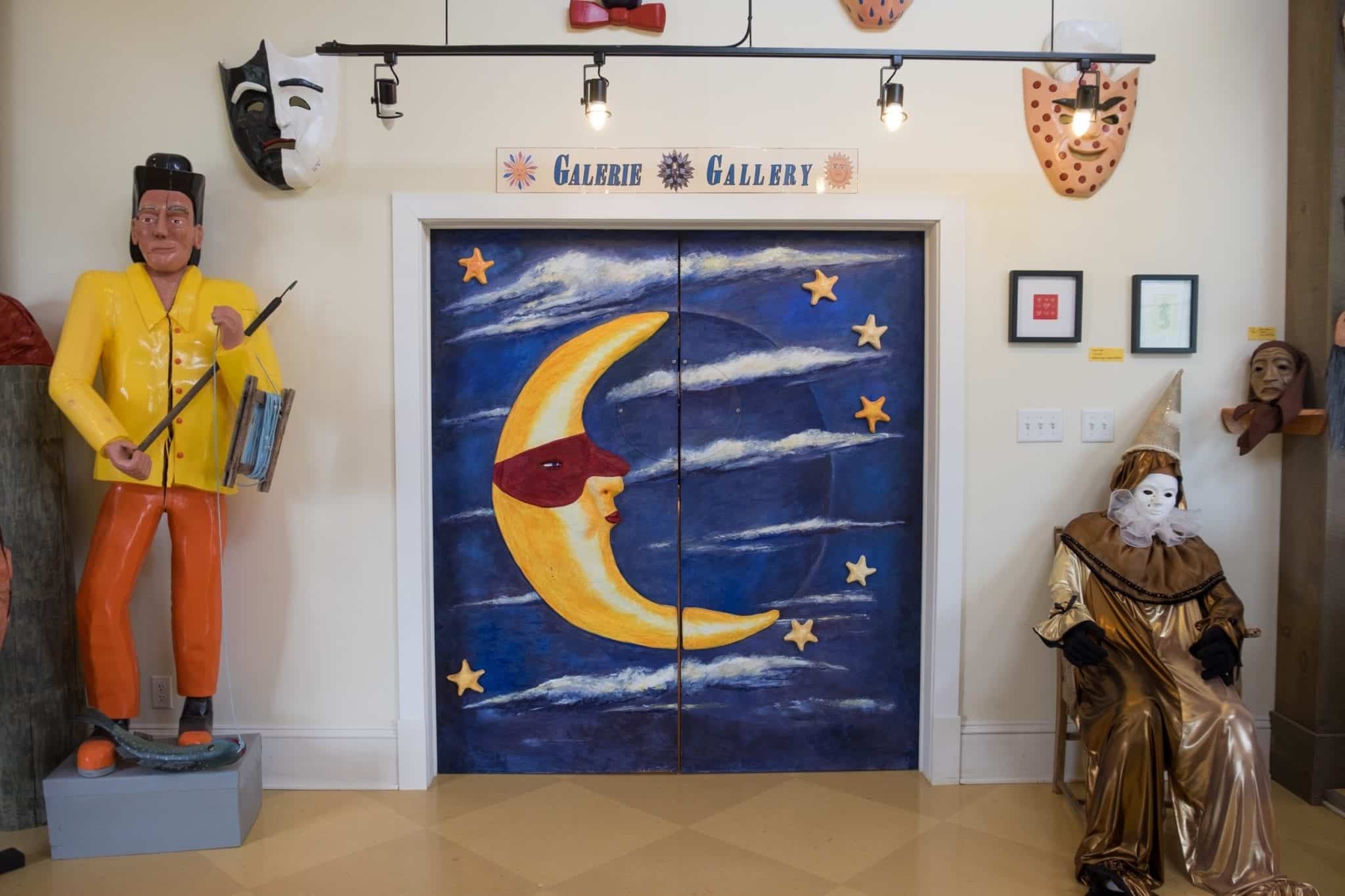 Elevator doors with a blue night sky and quarter moon wearing a mask painting on