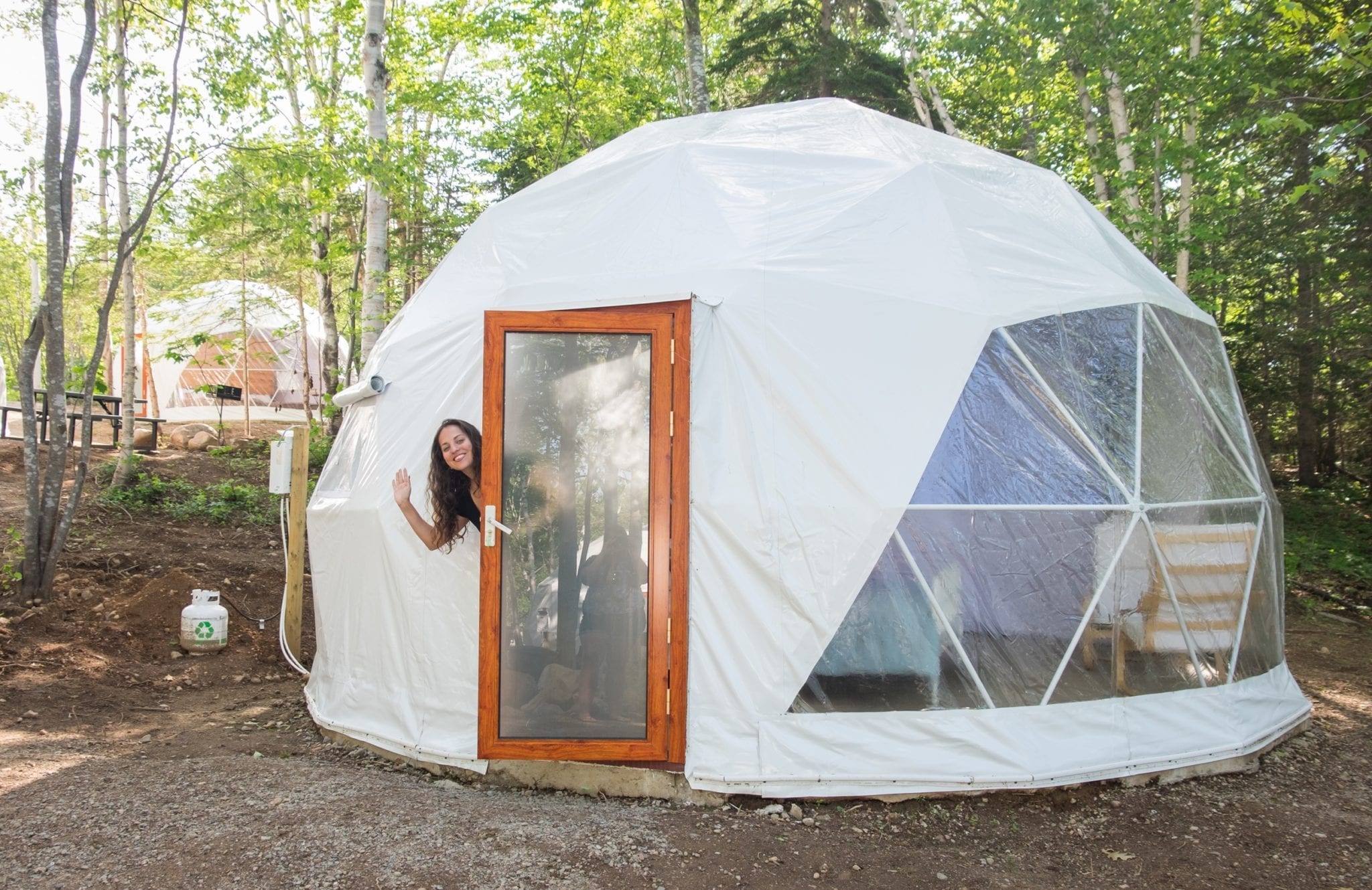 Kate poses hanging out the door in a Blue Bayou Geodesic Dome
