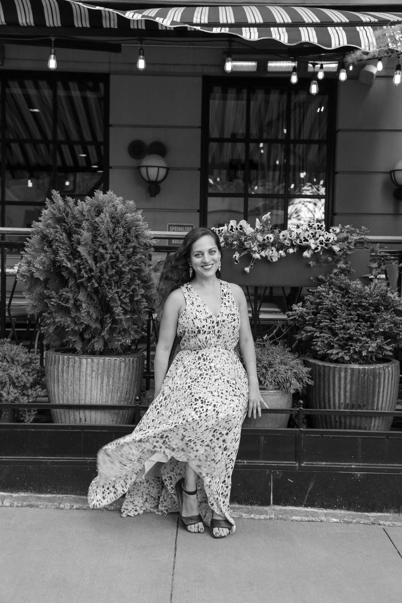 Kate sitting outside a restaurant in SoHo, NYC, in black and white.