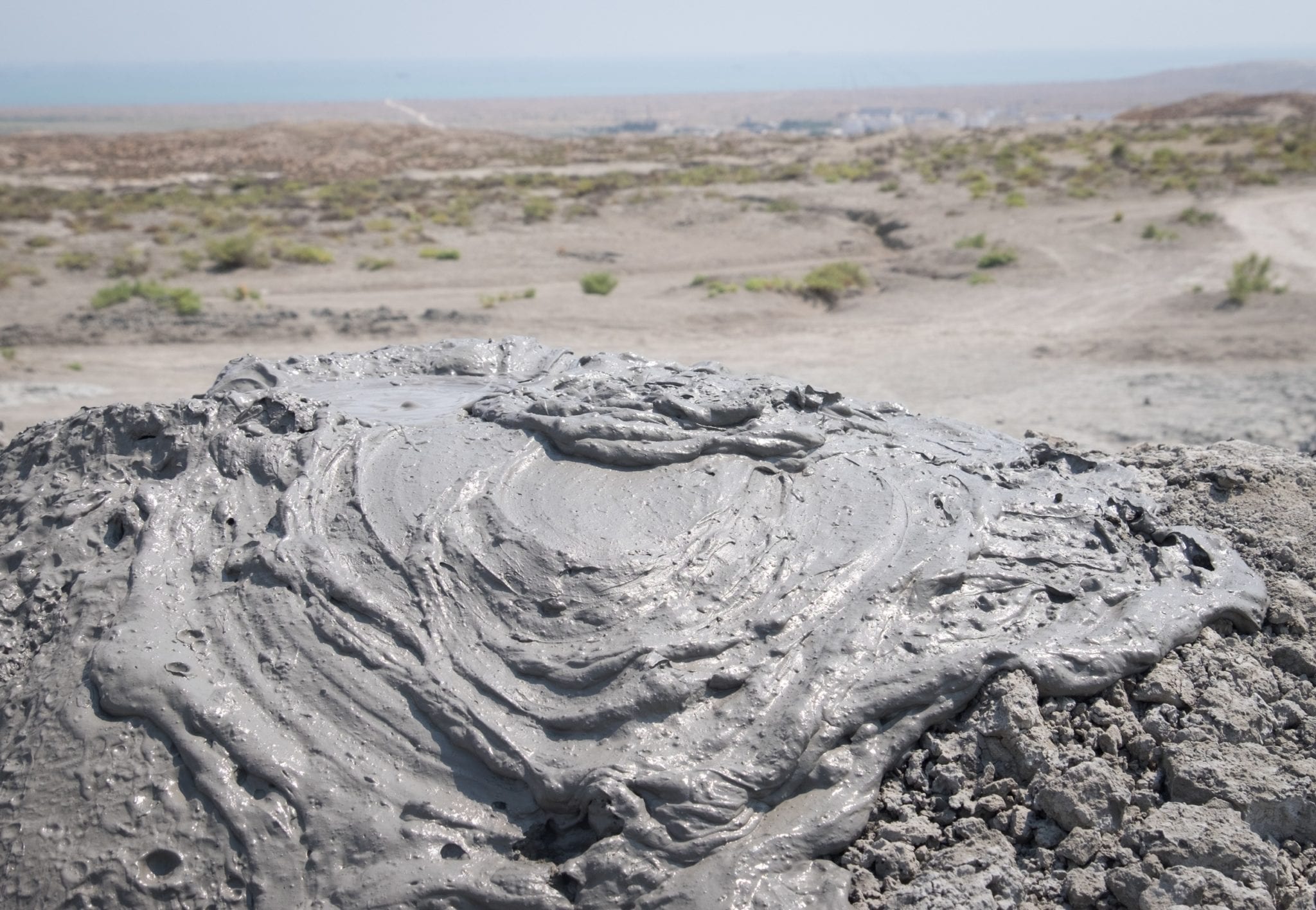 et nærbillede skudt på krusninger i den langsomt boblende muddervulkan.