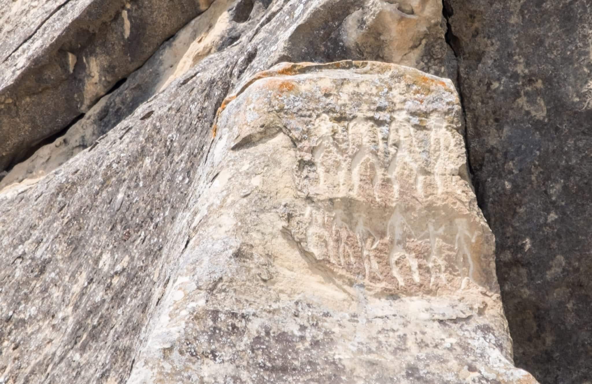 A petroglyph of people dancing in celebration.