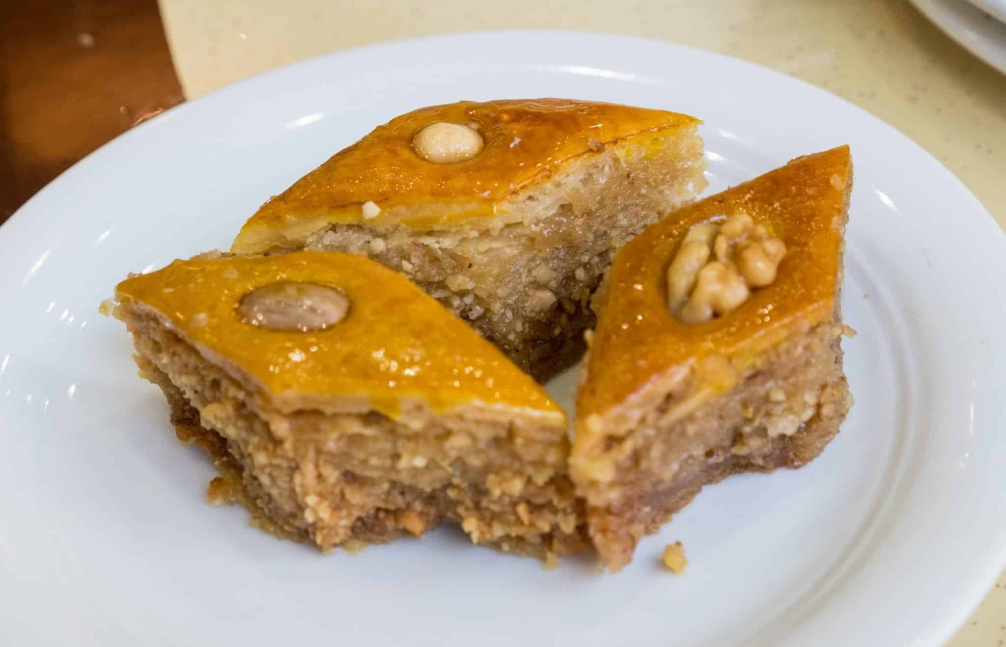 tři kusy baklavy, jeden přelitý mandlí, jeden s ořechem, jeden s lískovým oříškem.