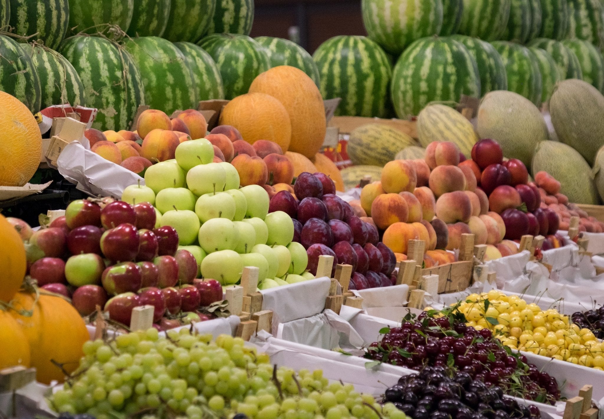 Perfectly stacked, immaculate piles of apples, watermelons, and grapes at a market in Azerbaijan.