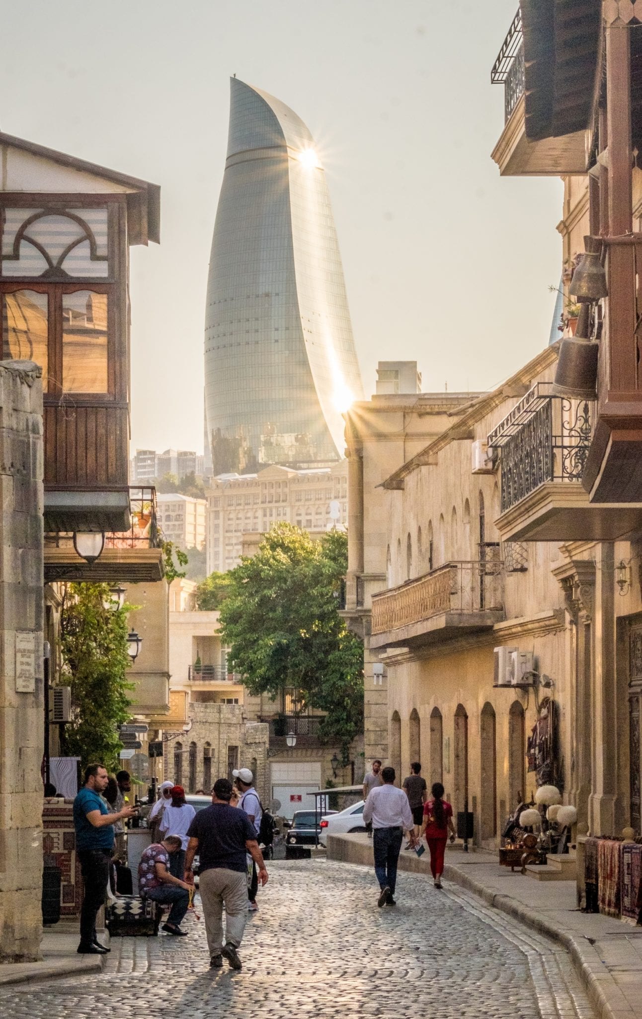  Una delle torri di fiamma metallica di Baku si arriccia sullo sfondo; in primo piano c'è la tradizionale città vecchia color sabbia.