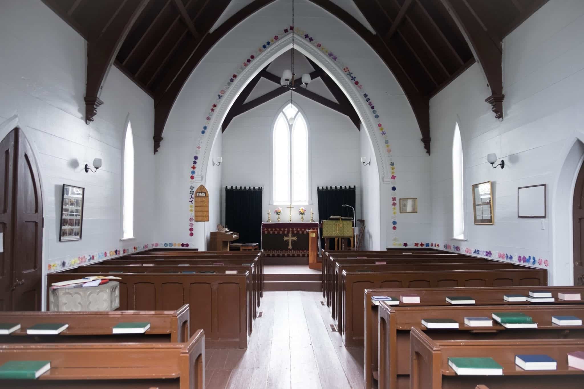 A church with a pointed nave, covered with a row of paper flowers.