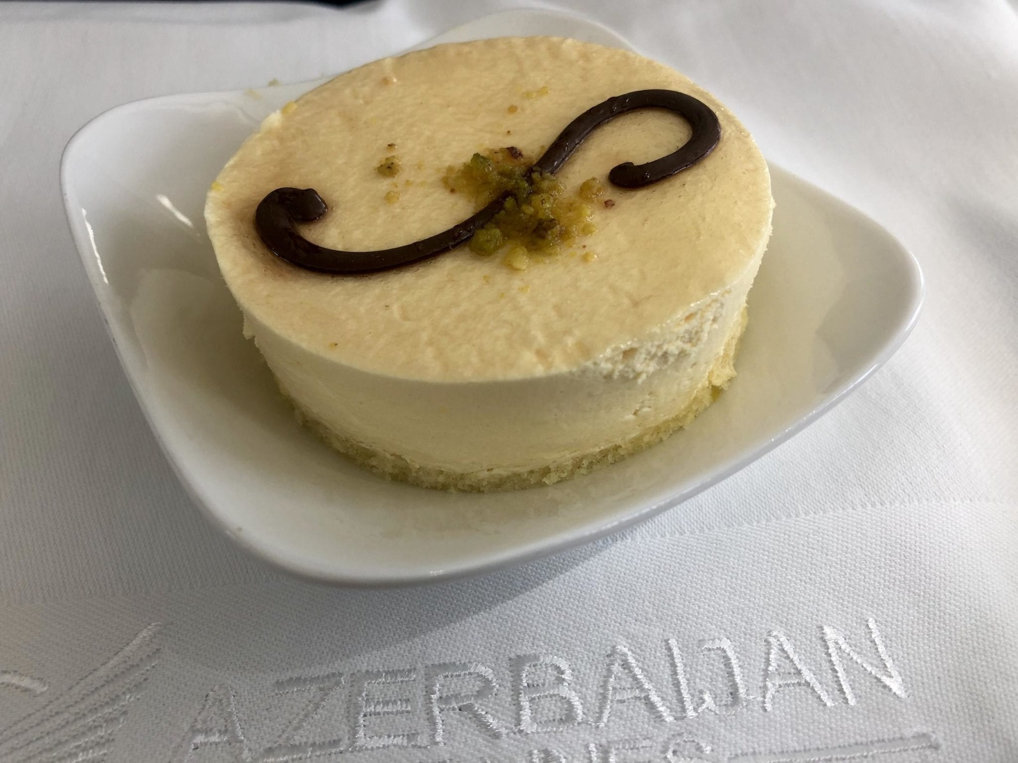 A cheesecake topped with a chocolate swirl in the Azerbaijan Airlines Comfort Club.