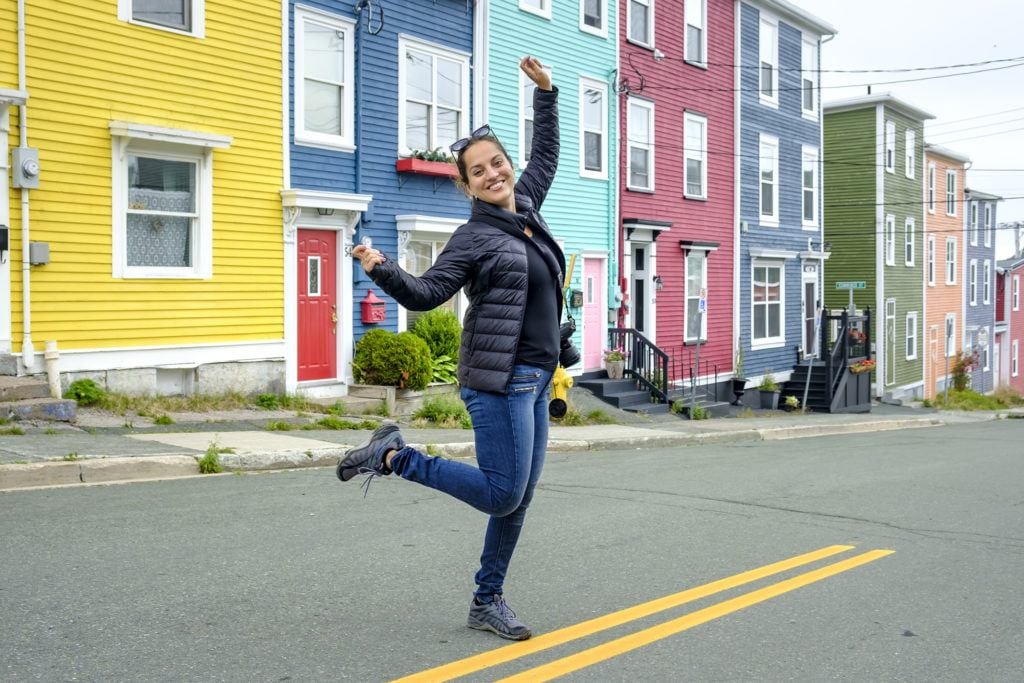 Kate dances in the street in front of a row of brightly painted houses in St. John's.