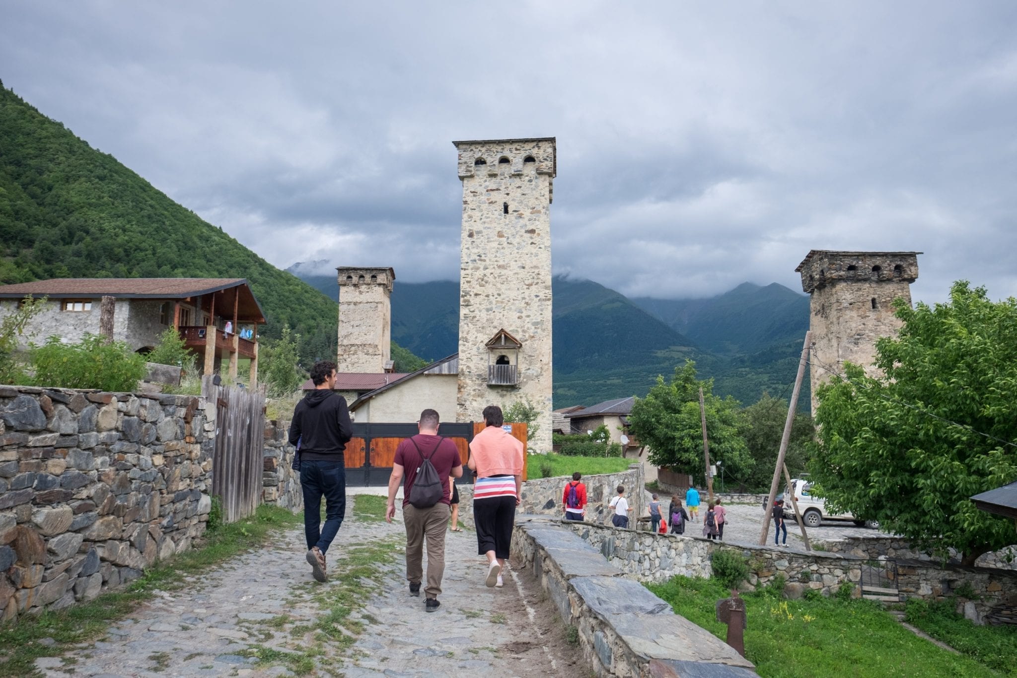 A group of bloggers walking toward one of the large stone towers, cloudy sky overhead.