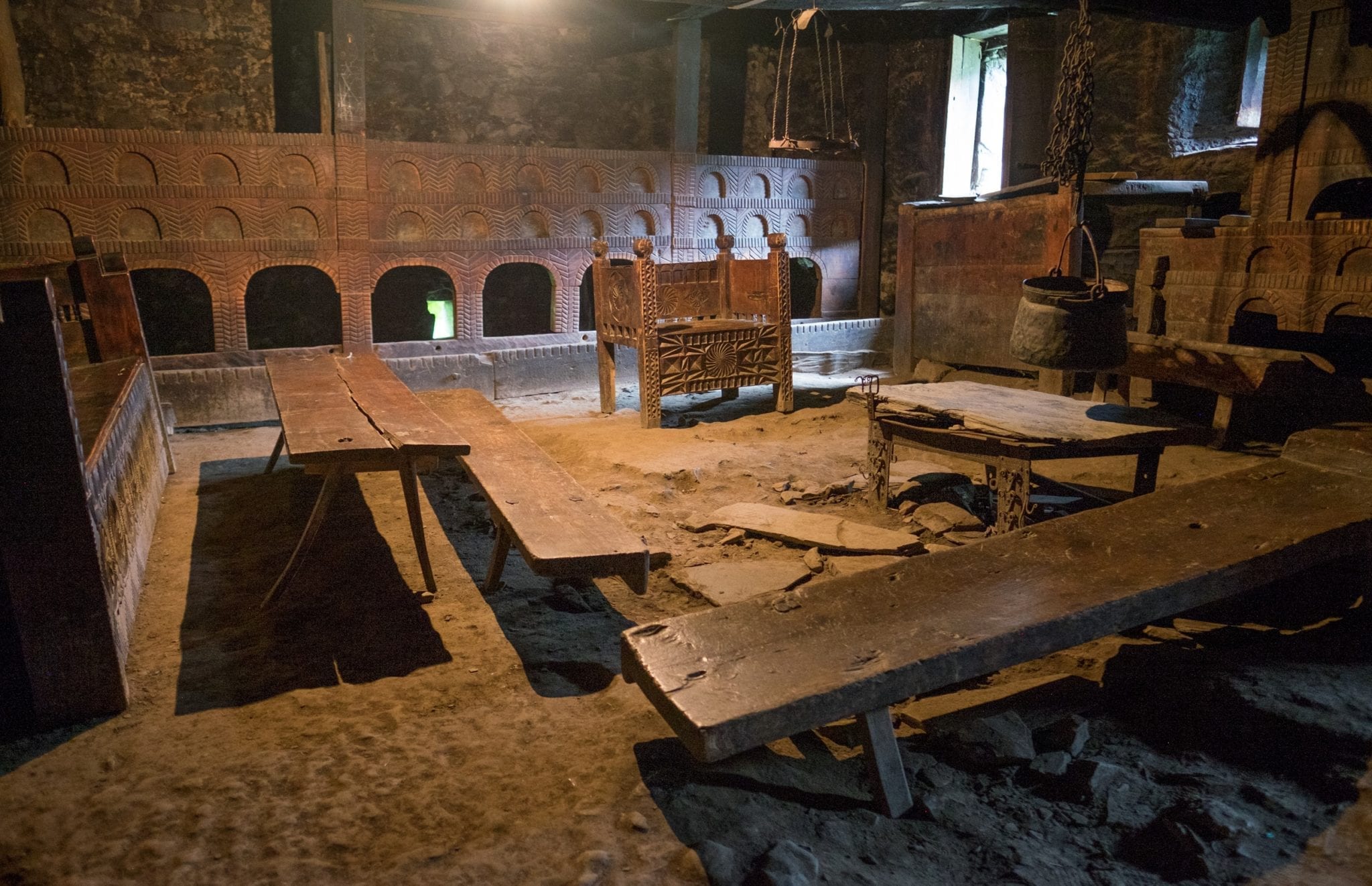 The Svan Museum, looking like an authentic Svan home from medieval times with a carved wooden chair and plain tables, in Mestia, Svaneti.