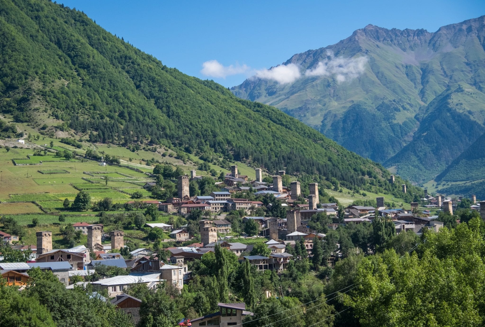 A village of stone towers in the foreground and mountains in the background in Mestia, Svaneti.