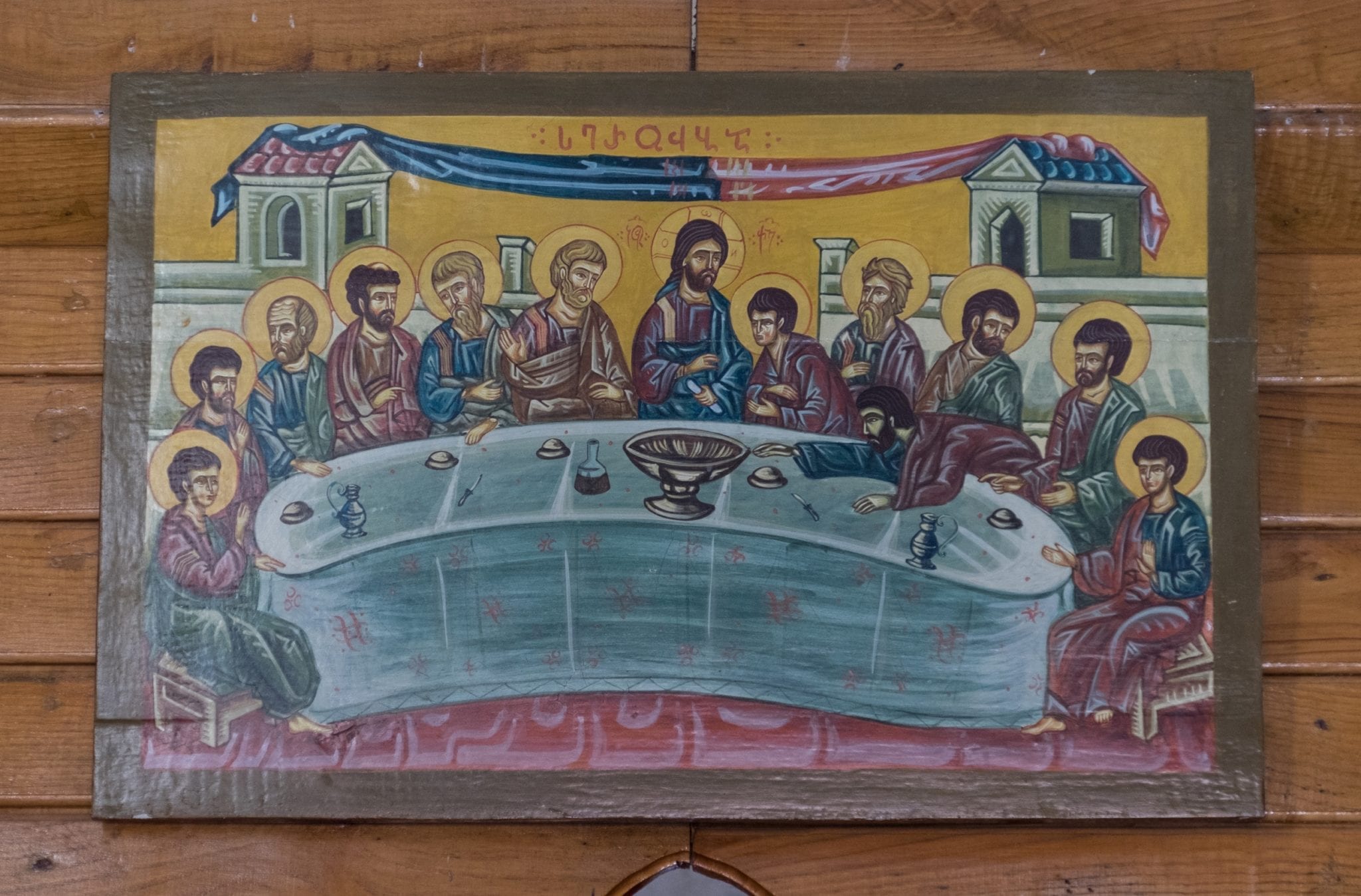 A close-up on a Georgian painting of The Last Supper, with Jesus in the middle surrounded by the disciples.