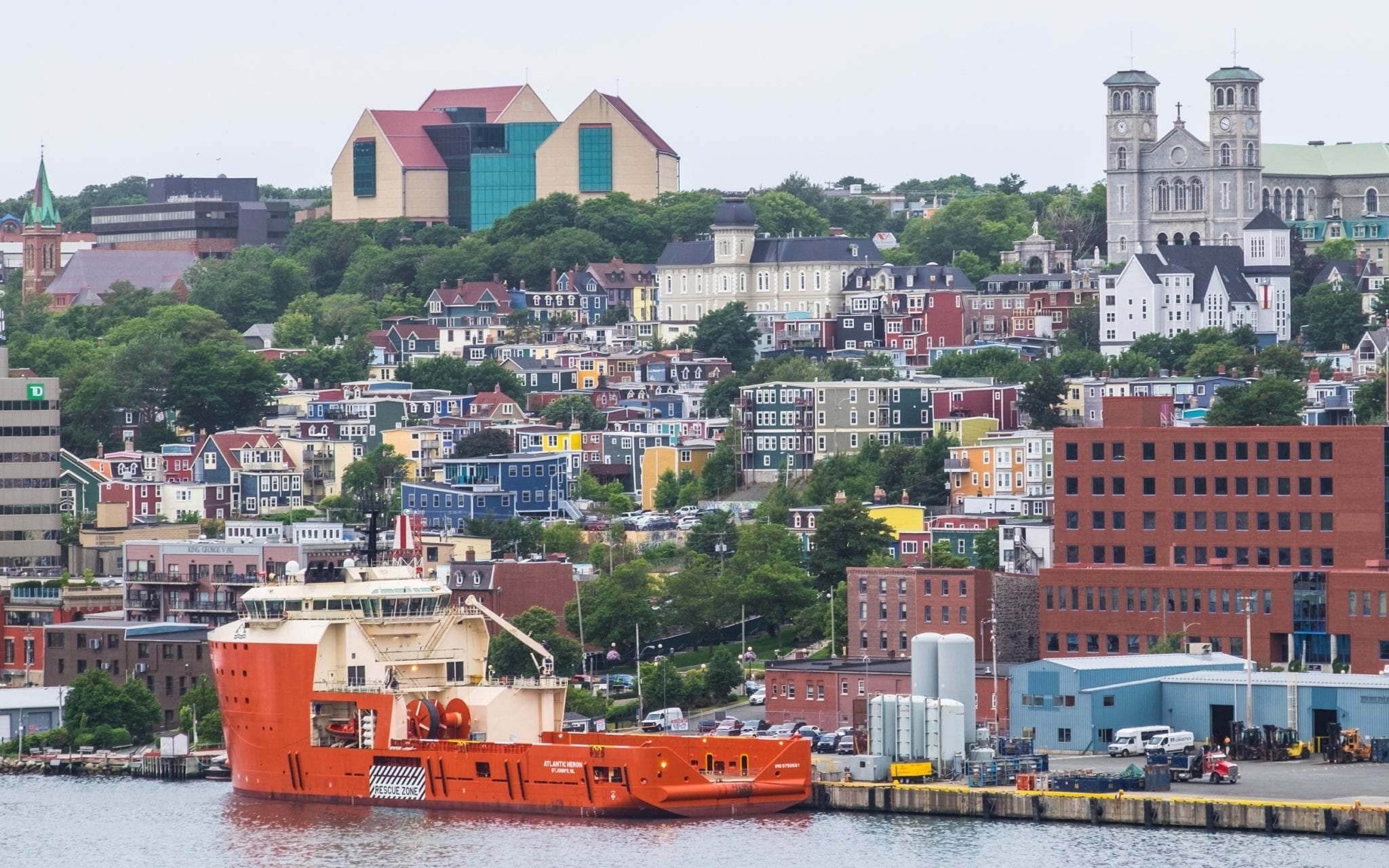 A shot of St. John's from a distance. You can see all the colorful homes on Jelly Bean Row, and a bright yellow ship in front.