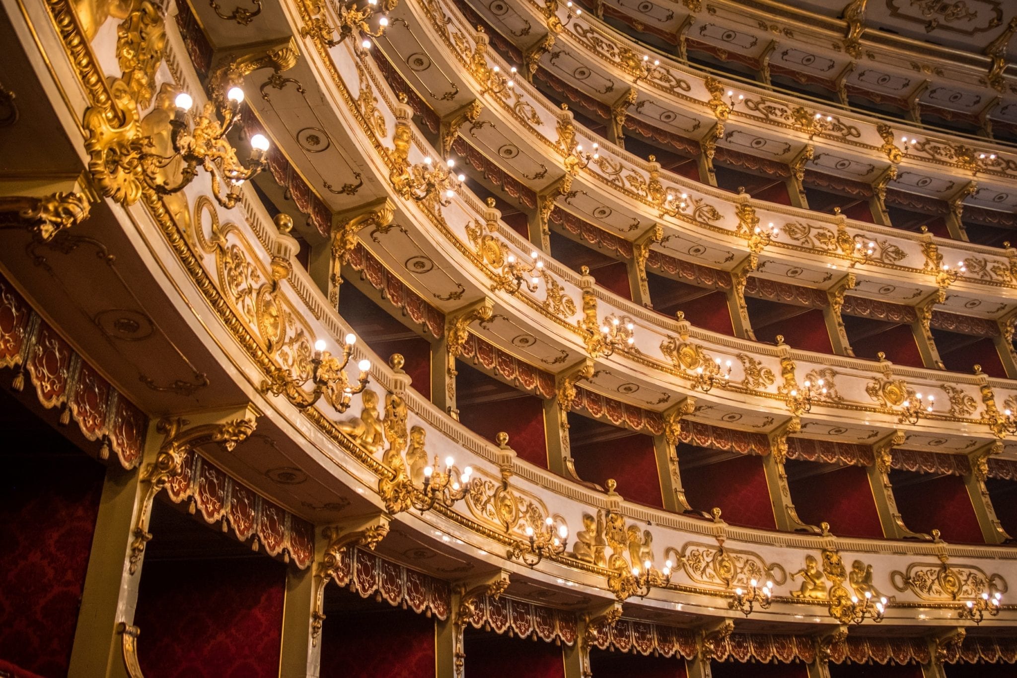The ornate theater with stacked rows of gold-and-white balconies.