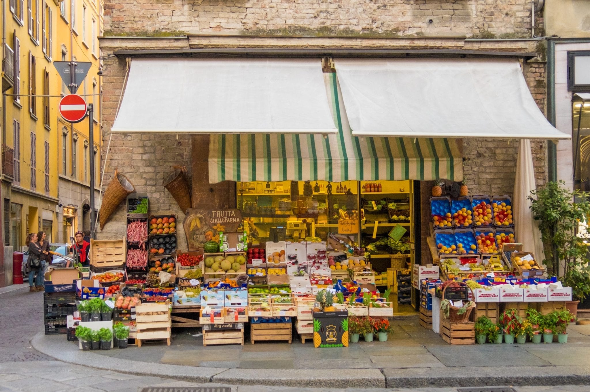 A fruit stand brimming with piles of fruits and vegetables in Parma, Italy.