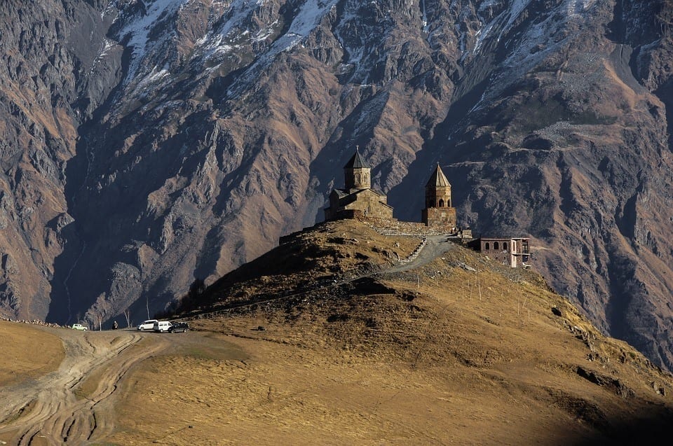 The church of Kazbegi, perched on a hill with a mountain backdrop behind it.