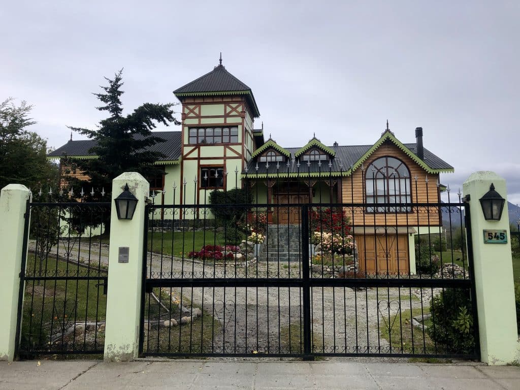 A beautiful Tudor-style home with a turret, set behind a gate.