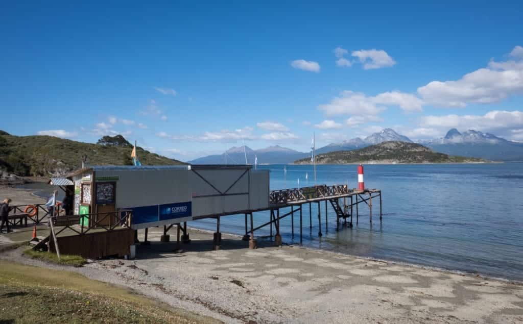 A post office built out of a shipping container leading out into a lake.