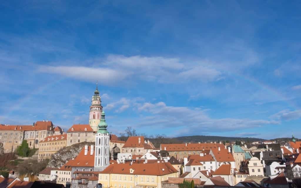 A rainbow in the sky over the orange-roofed buildings of Cesky Krumlov, Czech Republic